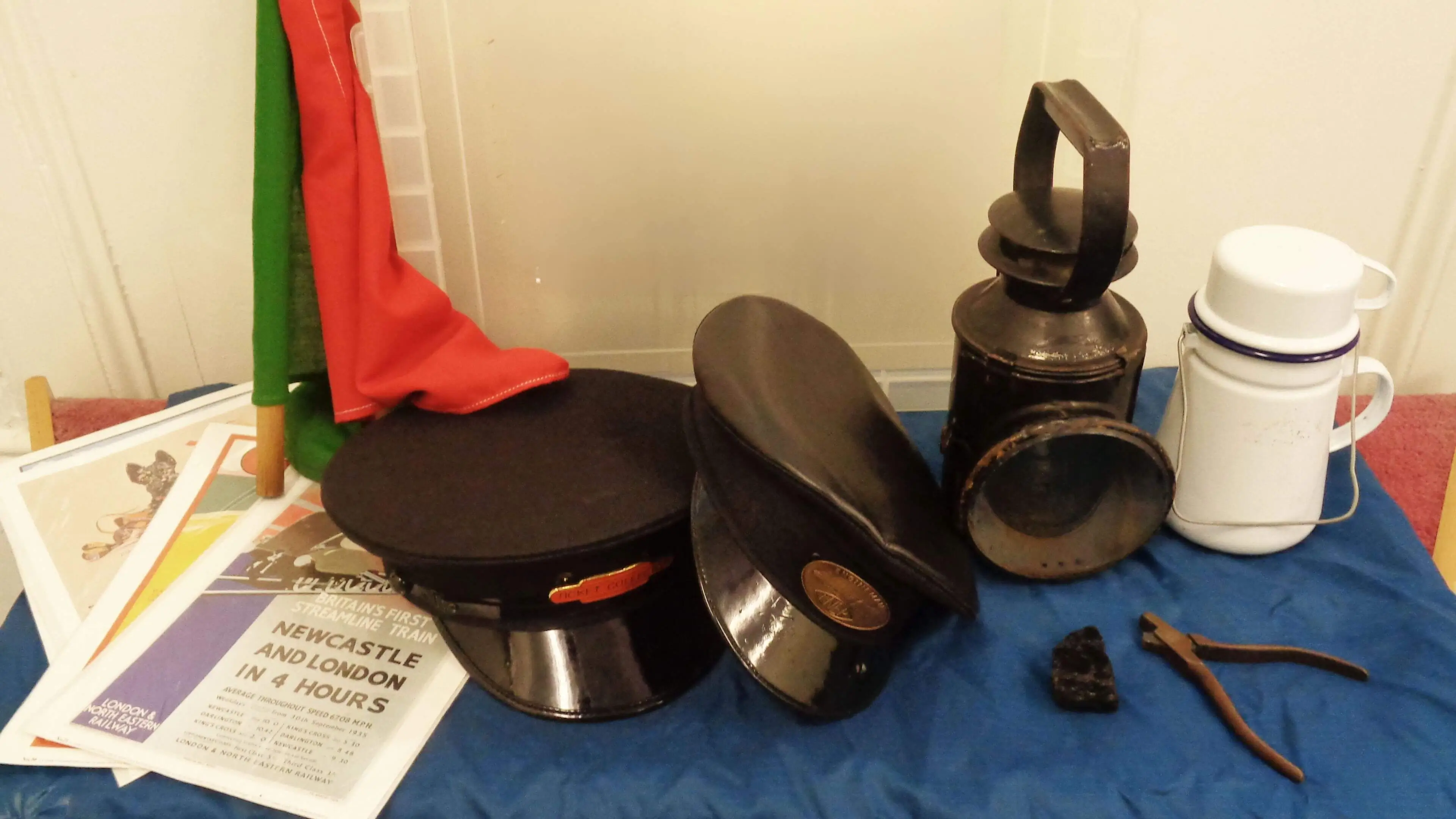 Old railway artefacts including a hat, newspapers and lamps