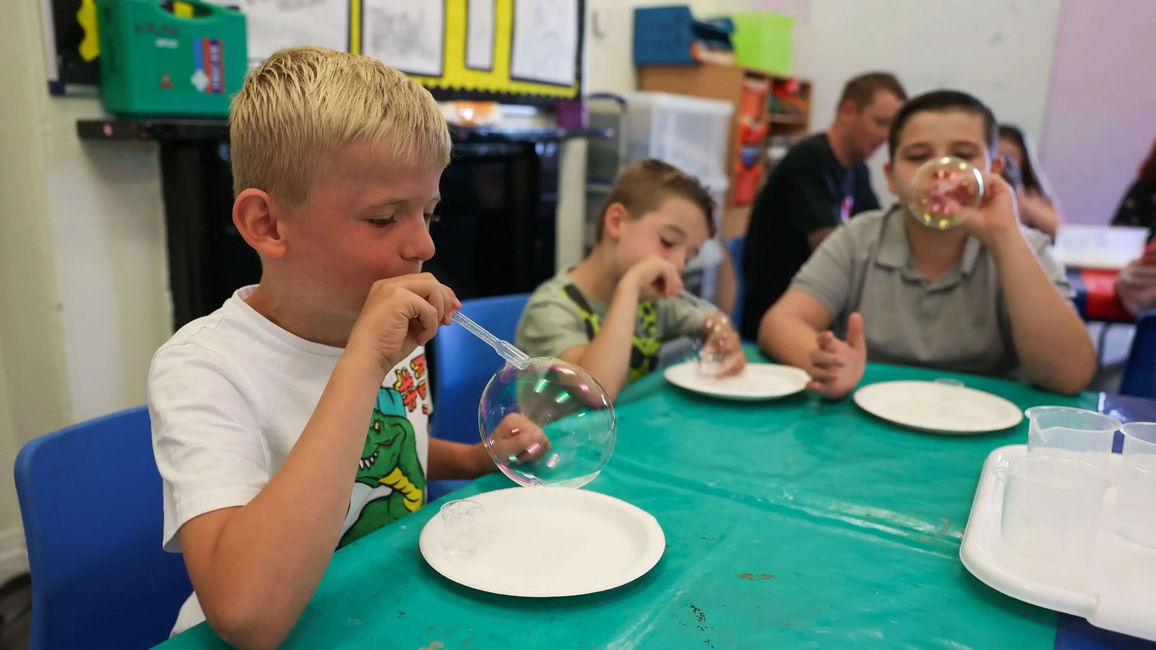 Children blowing bubbles during a science experiment